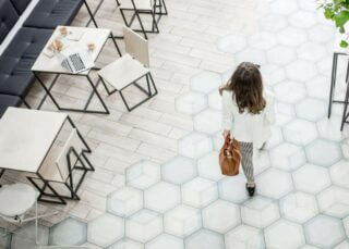 Woman walking across a white marble tile floor