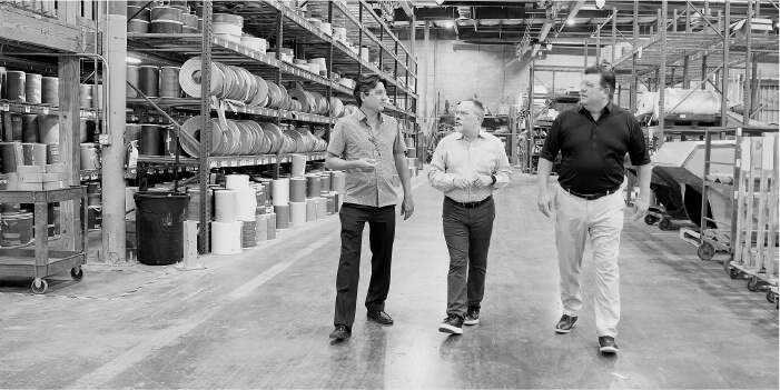 Thilo Hessler, Founder of Versatrim, walking the warehouse floor with Roger Farabee and Scott Rivard