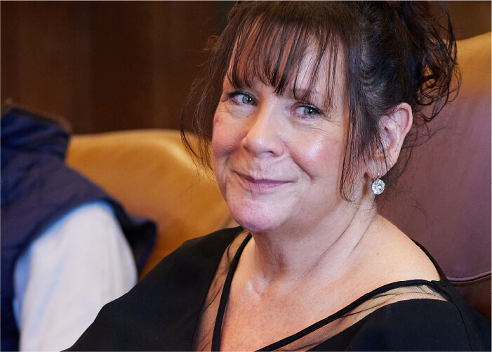 Climate Pros CFO Patty Burkland smiling and seated at a conference table