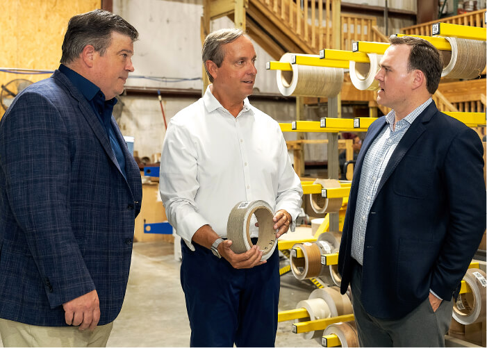 Keith Medick, President & CEO of Versatrim, demonstrates product with Scott Rivard and Scott Vandekerkhoff of Saw Mill